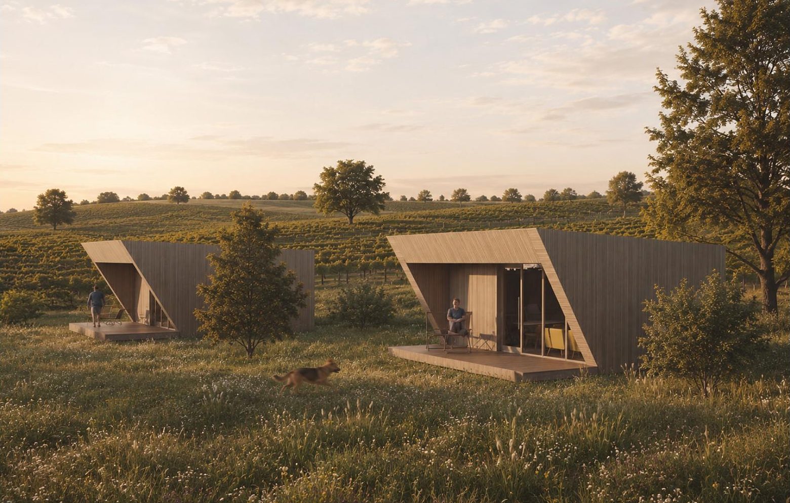 Two timber lodges open to the meadow at golden hour, a guest on the deck